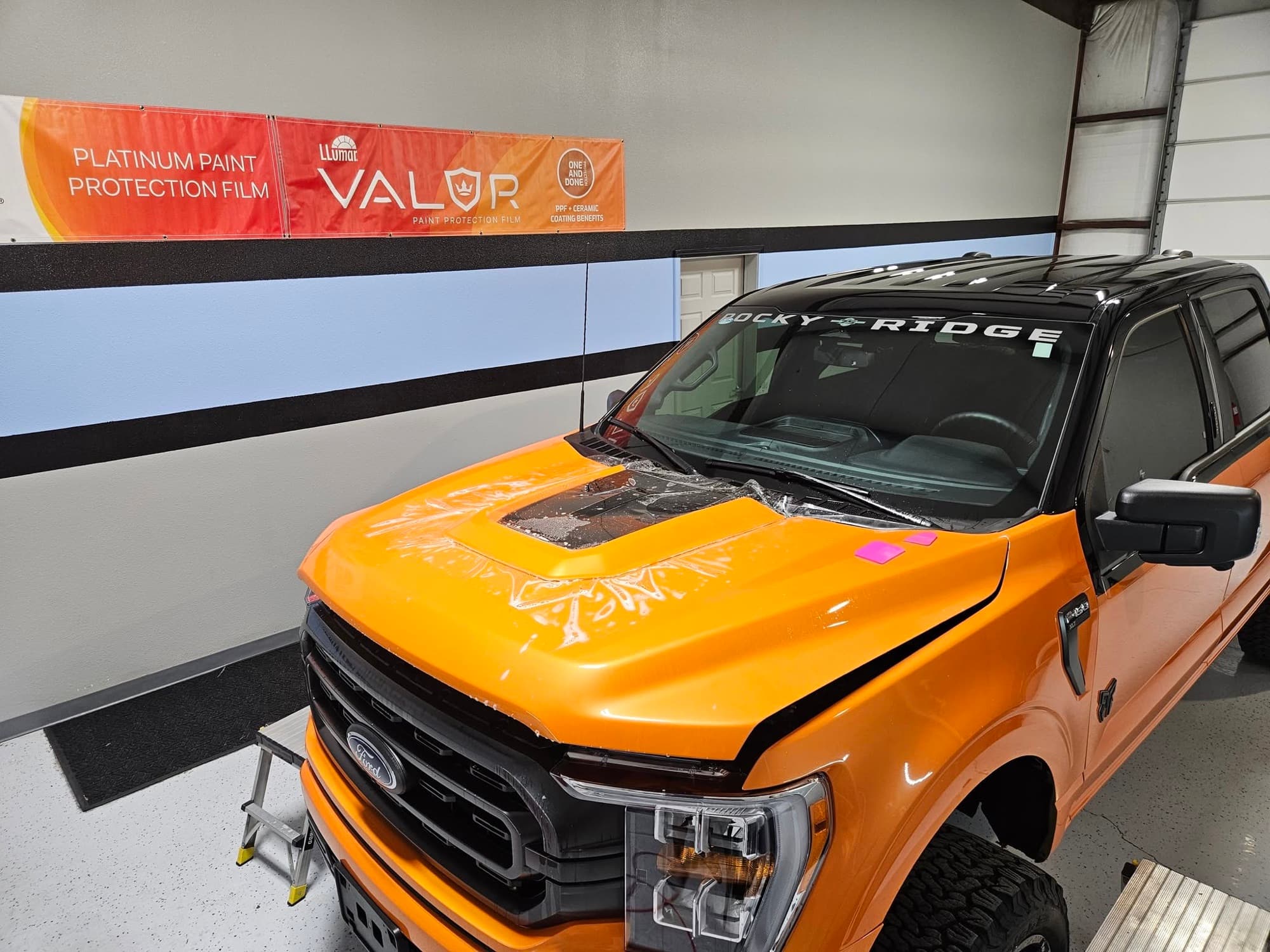 LLumar VALOR paint protection film installation on an orange Ford F-150 at Renegade Auto Spa